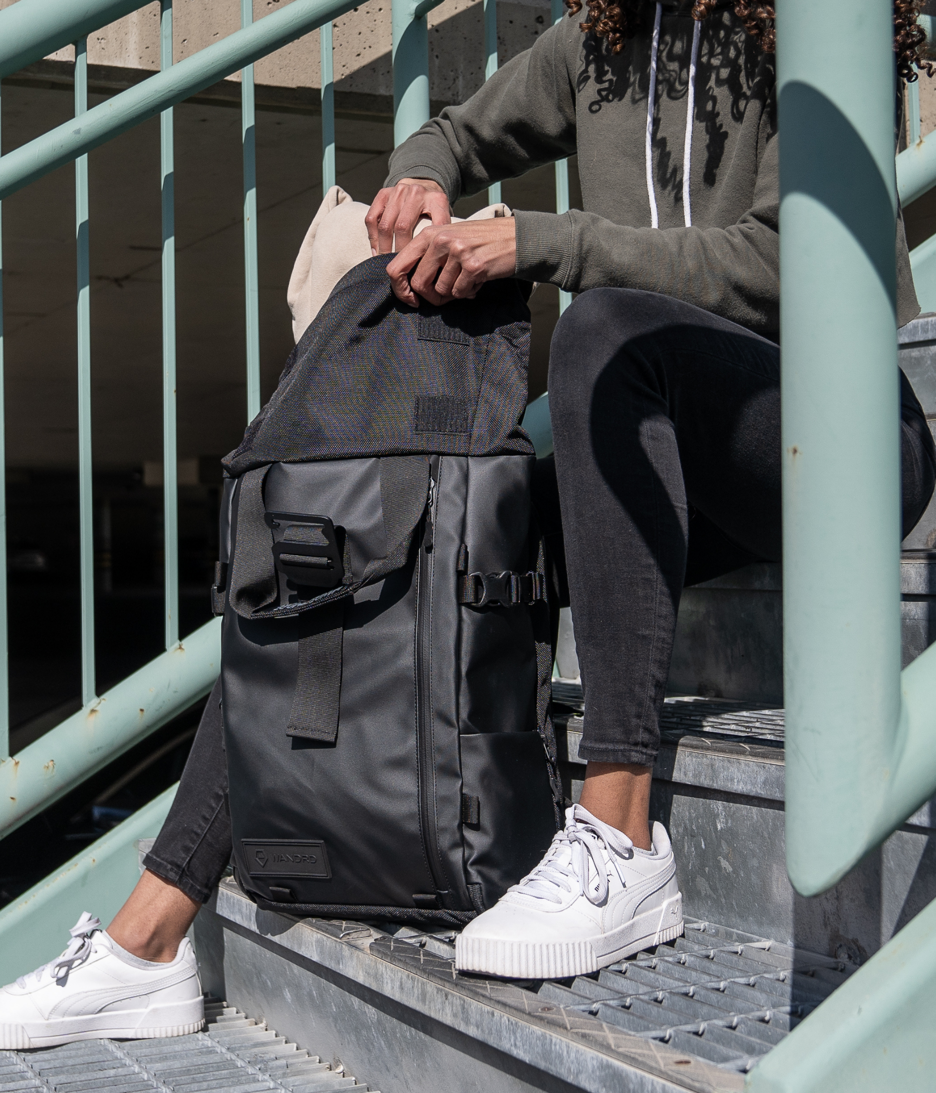 Person sitting by the stairs arranging her bag